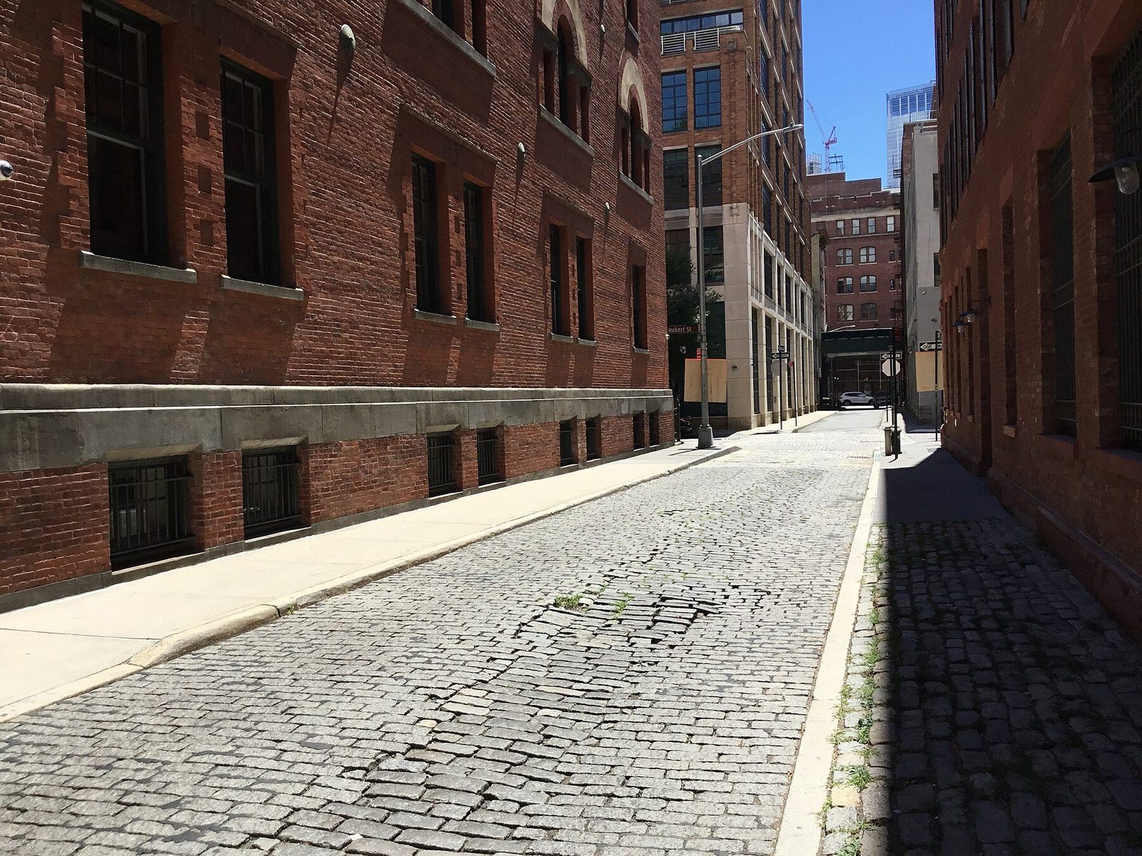 A Belgian-block street between brick warehouse buildings in Tribeca